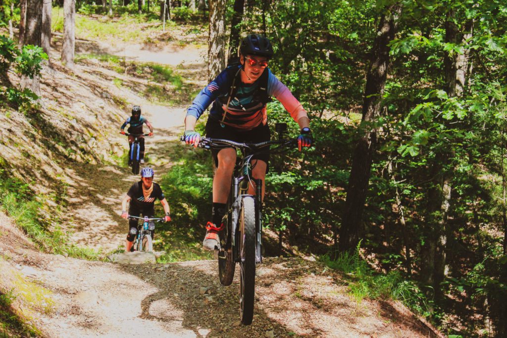 A group of 3 ladies ride on the mountain bike trails