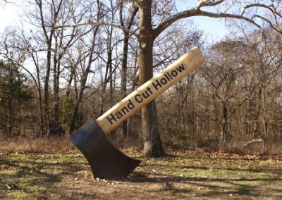 Large scale axe artwork reading "Handcut Hollow" on the handle