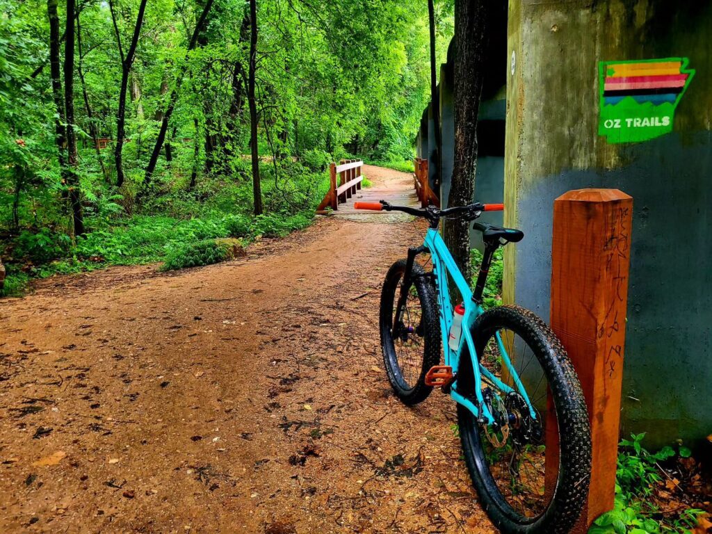 Mountain bike leaning against a post with an OZ Trails sign in the background.